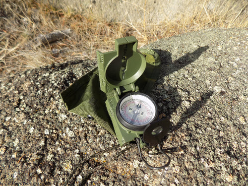 Commenga Lensatic Compass - compaas open on a rock - Wilderness Survival Systems : Picture